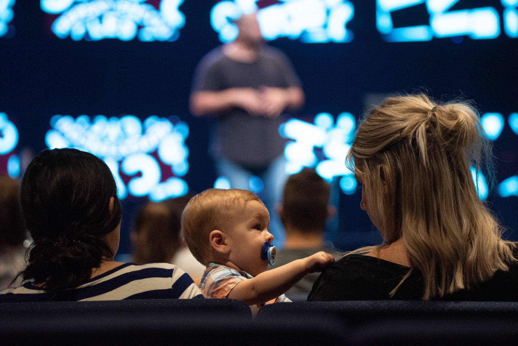 Shay Howell holds her son Case Howell as he looks at Emily Voris during University Christian ChurchÕs service on Sunday.